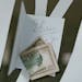 A photo of US dollar bills placed with a handwritten tip note for delivery service.