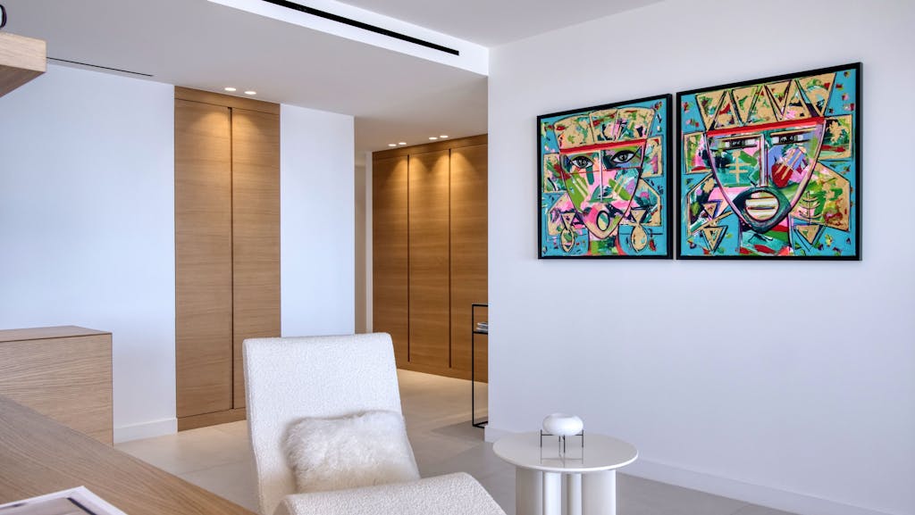 Bright minimalist living room interior with abstract artwork on wall and modern furniture.