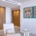 Bright minimalist living room interior with abstract artwork on wall and modern furniture.